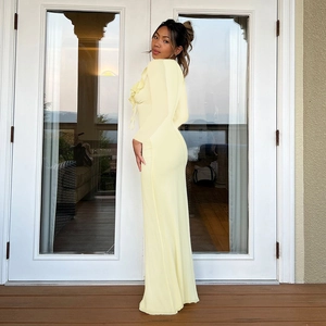 Close-up of side ruffle detail on a slim-fit light yellow long-sleeve maxi dress