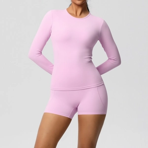 Gros plan du tissu de sport rose doux sur le haut à manches longues et le short de yoga