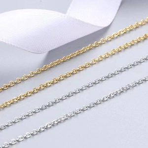 Minimalist gold and silver O-chain necklaces displayed on elegant white silk ribbons