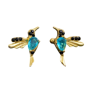 Detailed macro view of hummingbird drop earrings with blue crystal and gold finish