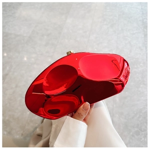 Detail of red metallic stone-shaped clutch with liquid-like mirror finish and round clasp