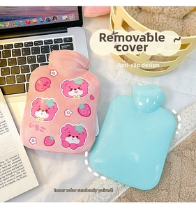 Detail of cute pink bear plush hot water bottle cover with strawberry pattern on a desk