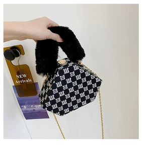 Close-up of hexagonal handbag with jacquard fabric, plush handle and gold metal lock