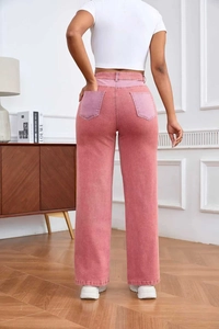 Détail d'un jean rose taille haute à coupe droite avec texture délavée et haut blanc