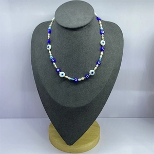 Detailed view of evil eye necklace with blue glass beads and creamy white pearls