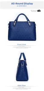 Detail view of dark blue tote bag showing embossed texture and golden hardware accents