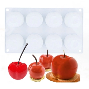 Detail showing 8-cavity white silicone mold and finished red cherry-shaped mousse cakes