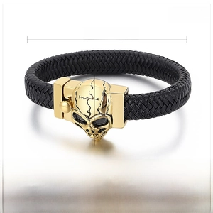 Macro detail of black braided leather bracelet with gold stainless steel skull magnetic clasp