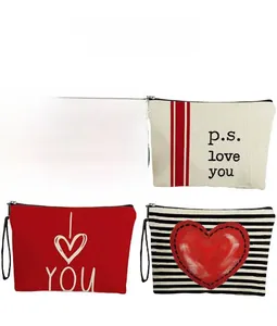 Detail view of four patterned canvas makeup bags featuring red hearts and stripes prints