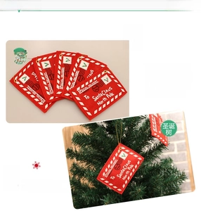 Macro view of red felt Christmas envelope ornament with gold string and white North Pole print