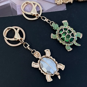 Golden turtle keychain with green rhinestones and crystal emerald stone for bags