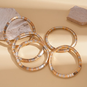 Detail of five-piece geometric bracelets featuring gold and silver color-blocked metal
