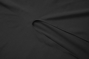 Détail du tissu textile noir avec couture d'ourlet précise et texture tissée fine