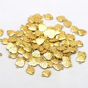 Primer plano detallado de colgantes de corazón dorado con grabado Made with Love para joyería