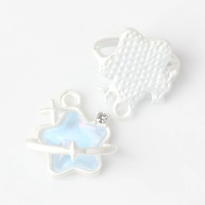 Macro shot of silver star charms with blue iridescent inlay and small rhinestone detail