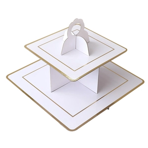 Detail of a two-tier white square cardboard cupcake stand with elegant gold foil edges