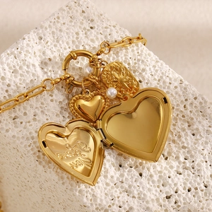 Detail view of 18K gold heart locket necklace with I Love You engraving on white stone