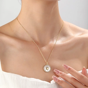 Elegant gold necklace featuring a heart pendant with white pearl and zircon accents