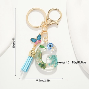 Resin initial G keychain with dried flowers, gold foil, evil eye and blue tassel charm