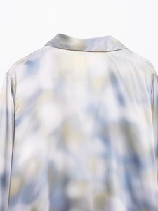 Close-up of the elegant blue and beige tie-dye satin shirt collar and smooth fabric texture