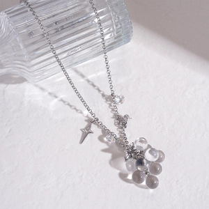 Detailed shot of silver beaded necklace with star pendant and clear grape-shaped charms