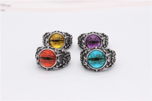 Top view of four punk gothic rings with dragon eye gemstones in red, yellow, purple, and blue