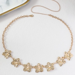 Detail of vintage gold flower waist chain with pearls and intricate metal ring links