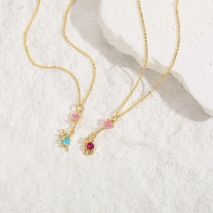 Detailed macro of golden bear and rabbit pendants with colorful zircon inlay on fine chain