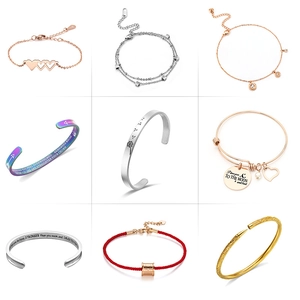 Detailed macro view of nine diverse minimalist bracelets featuring charms and engravings