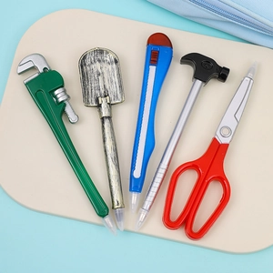 Close-up of creative tool-shaped ballpoint pens including wrench, shovel, and hammer styles