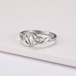 Titanium steel ring with Celtic Triquetra and infinity knot on white platform