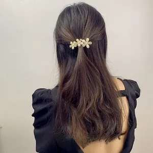 Detail of three-flower rhinestone hair clip worn by a model for a sweet look