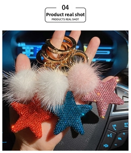 Star-shaped rhinestone keychain with plush pom pom charms in red, blue, and pink colors