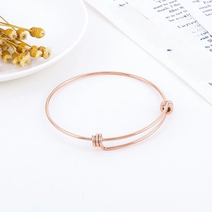 Close-up of adjustable rose gold stainless steel wire bracelet with sliding coil details