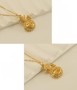 Detailed macro view of 18k gold plated stainless steel lucky pouch pendant with crystals
