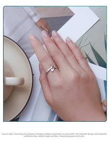 Close-up of S925 sterling silver cat ring with pink paw details worn by a person