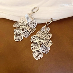 Detailed macro view of layered geometric hollow square tassel earrings in silver finish