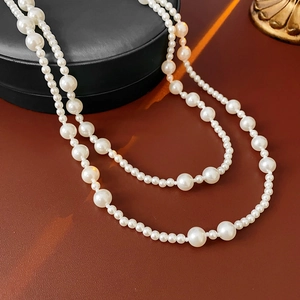 Close-up of elegant double-layered white pearl necklace on a black jewelry display box