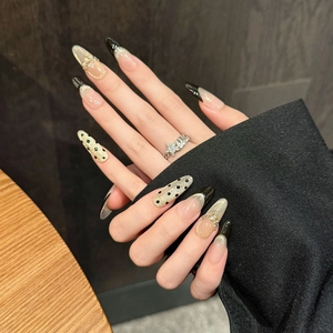 Long almond press-on nails with black French tips, cat-eye glitter, and rhinestone accents