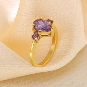 Macro view of pear-shaped purple zircon ring on elegant beige silk fabric texture