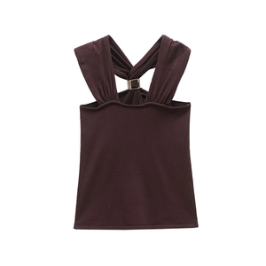 Detail of dark brown knit tank top featuring cross-back straps and metal hardware