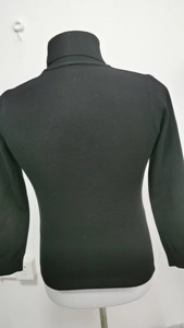 Detail showing high-neck black knit sweater texture and back view on mannequin