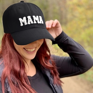 Black cotton baseball cap with white MAMA towel embroidery worn outdoors