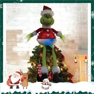 Close-up of a glowing Grinch Christmas tree topper in red suit and plush texture