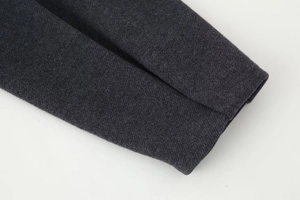 Detaillierte Nahaufnahme der grauen Twill-Stoffstruktur und des Ärmelbündchens der Jacke