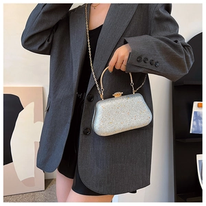 Macro view of silver glitter banquet bag with golden circular handle and chain strap