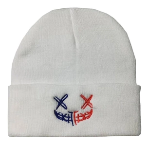 White knitted beanie with red and blue embroidered cross eyes and smile face design