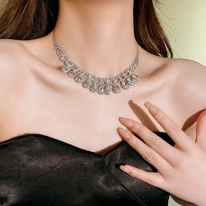 Close-up of elegant silver teardrop tassel necklace with sparkling diamonds on model