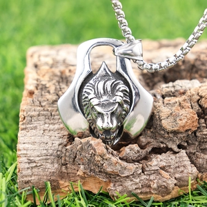 Vintage stainless steel lion head pendant necklace placed on tree bark background