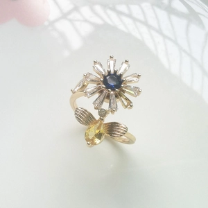 Detailed close-up of a rotating daisy flower and bee ring with sparkling crystals